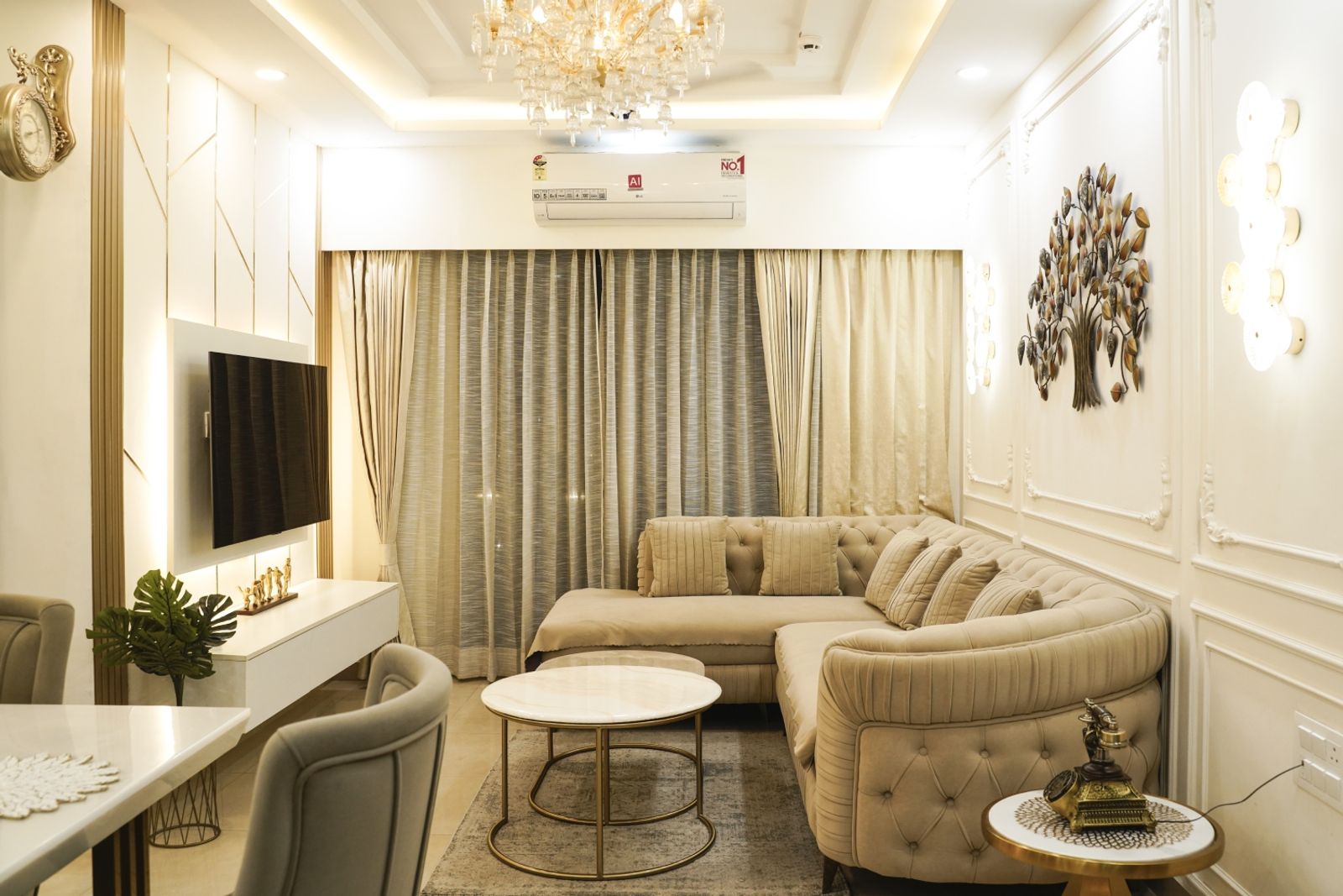 Living Room Design with Beige Tufted Sectional Sofa, Gold Accent Wall Trims, and Crystal Chandelier Ceiling Light